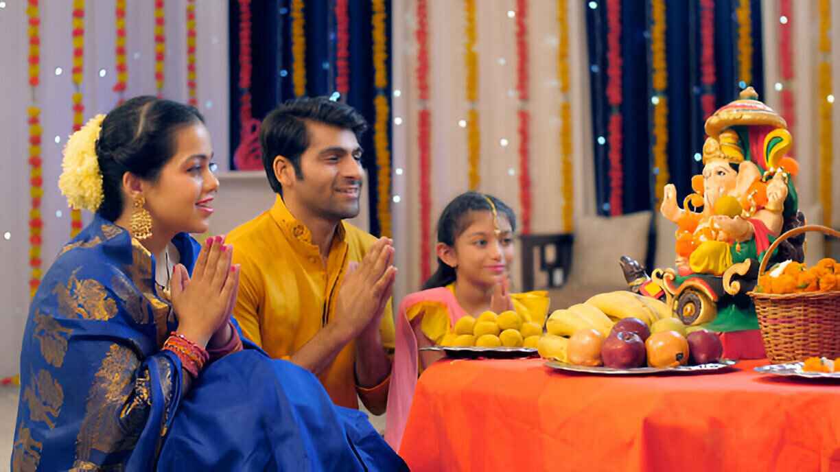 Pooja photoshoot highlighting Ganesh ji archna by smiling family